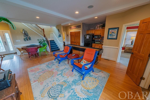 living area with recessed lighting, wainscoting, stairway, and light wood finished floors