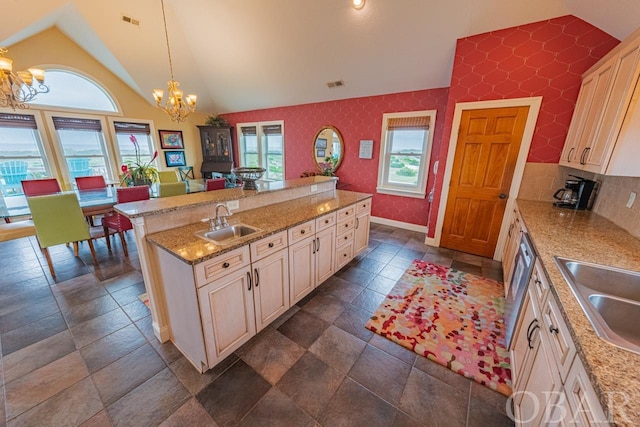 kitchen featuring wallpapered walls, visible vents, hanging light fixtures, a sink, and a notable chandelier