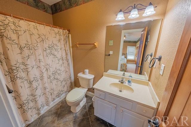 full bath with a textured wall, tile patterned flooring, toilet, vanity, and a ceiling fan