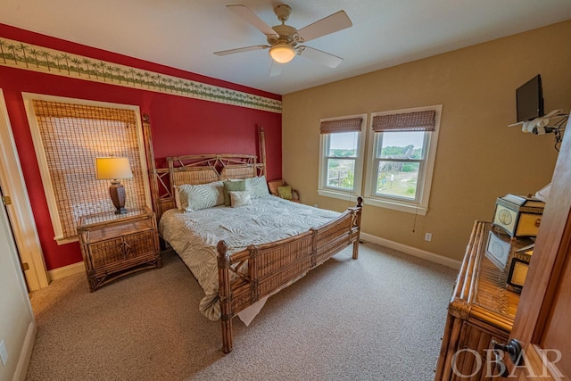 carpeted bedroom with ceiling fan and baseboards