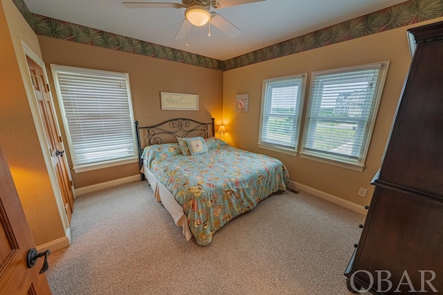 bedroom featuring light colored carpet, ceiling fan, and baseboards