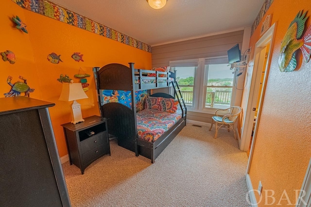 bedroom featuring light carpet and baseboards