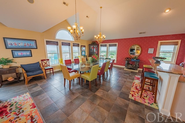 dining space with high vaulted ceiling, baseboards, visible vents, and a notable chandelier