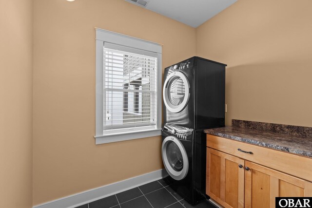 2916 Bay Drive Lots 17&18, Kill Devil Hills, NC 27948 - laundry area with cabinet space, visible vents, baseboards, dark tile patterned flooring, and stacked washer and clothes dryer