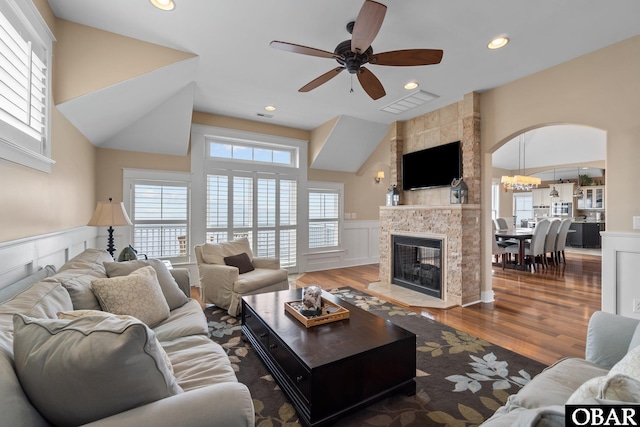 living room featuring a fireplace, wainscoting, wood finished floors, and visible vents