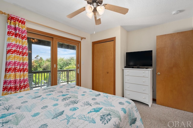 carpeted bedroom featuring access to exterior, ceiling fan, a closet, and a textured ceiling