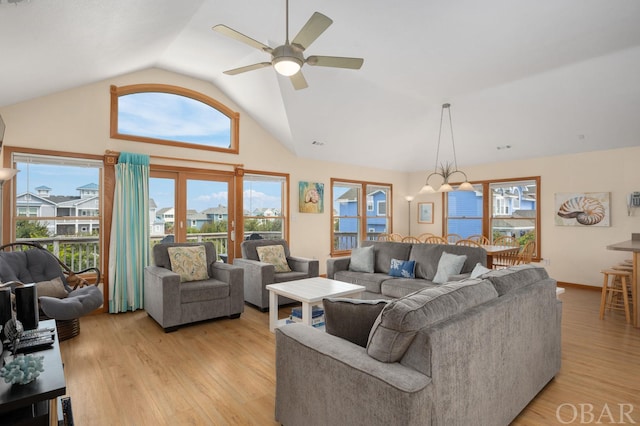 living room featuring high vaulted ceiling, light wood-type flooring, a ceiling fan, and baseboards