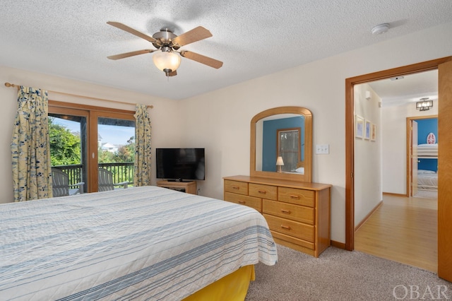 bedroom with ceiling fan, a textured ceiling, light colored carpet, baseboards, and access to outside