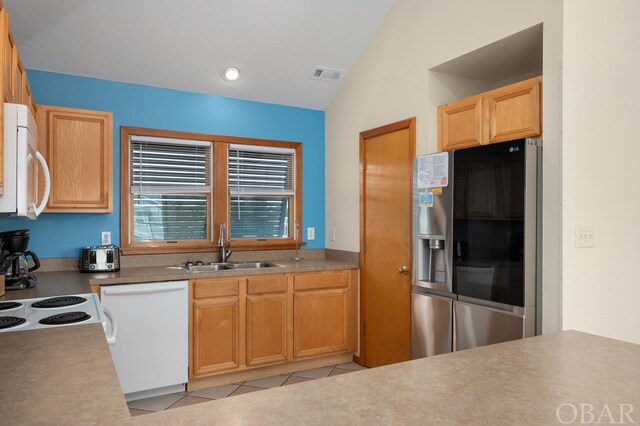 kitchen featuring light tile patterned flooring, white appliances, a sink, visible vents, and vaulted ceiling