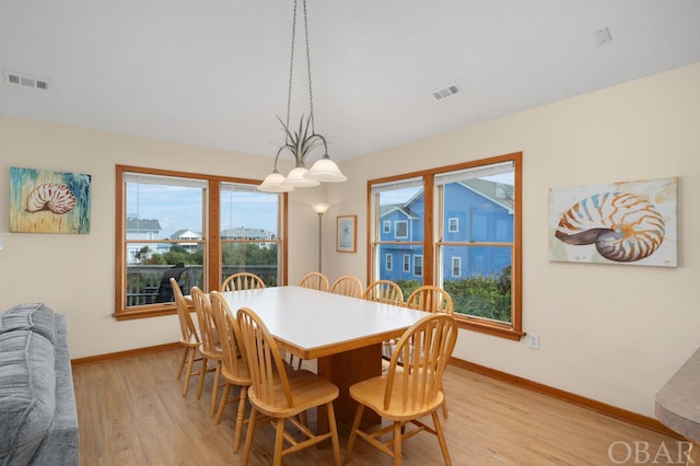 dining area featuring baseboards, visible vents, and light wood finished floors