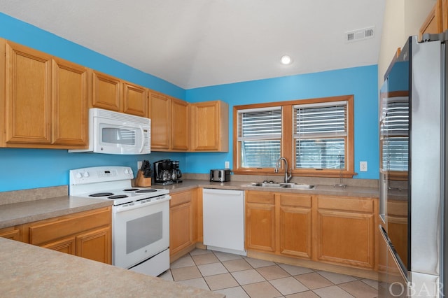 kitchen with white appliances, visible vents, light countertops, a sink, and light tile patterned flooring