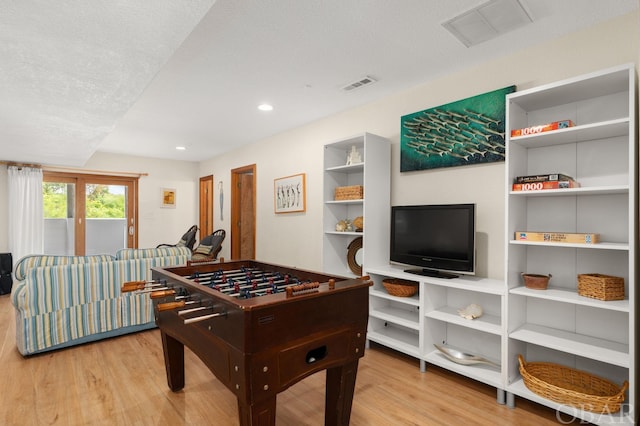 playroom with visible vents, a textured ceiling, and wood finished floors