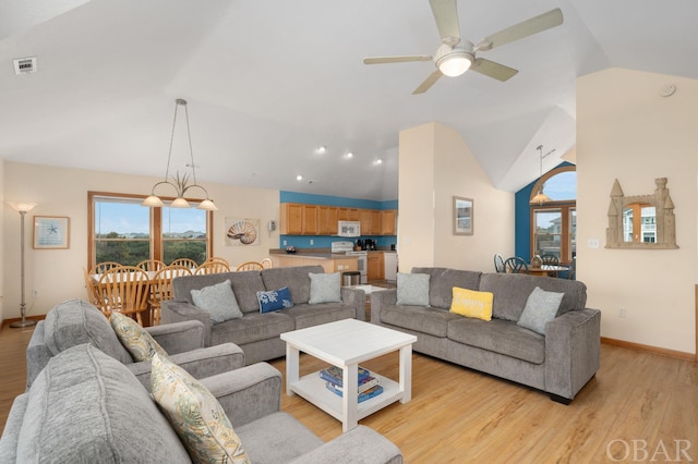 living area featuring vaulted ceiling, baseboards, visible vents, and light wood-style floors