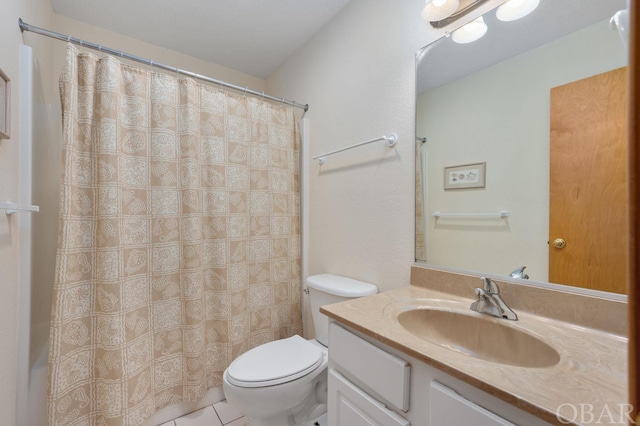 bathroom featuring a shower with curtain, vanity, toilet, and tile patterned floors