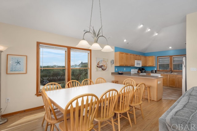 dining room with lofted ceiling, baseboards, light wood finished floors, and recessed lighting