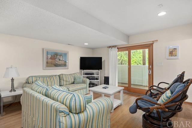 living area featuring light wood-type flooring, a textured ceiling, and recessed lighting