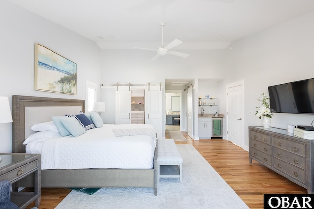 123 Skimmer Way Lot 48, Duck, NC 27949 - bedroom featuring beverage cooler, a sink, light wood-style flooring, high vaulted ceiling, and ensuite bathroom