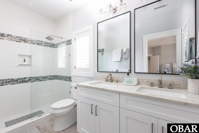 123 Skimmer Way Lot 48, Duck, NC 27949 - bathroom featuring a tile shower, double vanity, toilet, and wood finished floors
