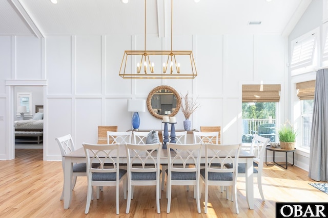 123 Skimmer Way Lot 48, Duck, NC 27949 - dining room featuring a decorative wall, a chandelier, light wood-type flooring, and a high ceiling