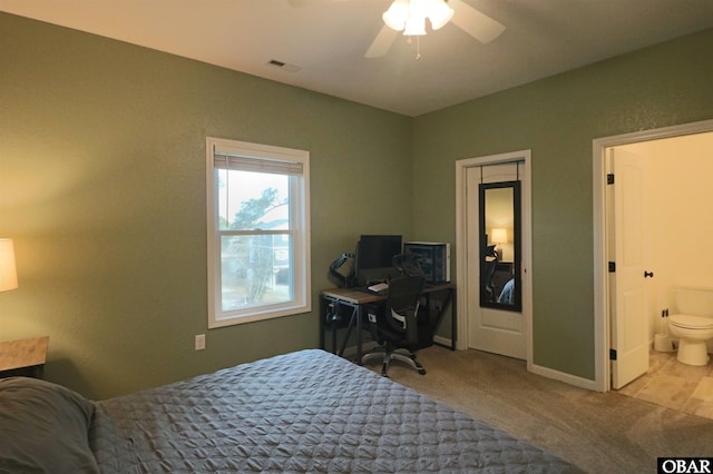 bedroom with light colored carpet, visible vents, a ceiling fan, connected bathroom, and baseboards