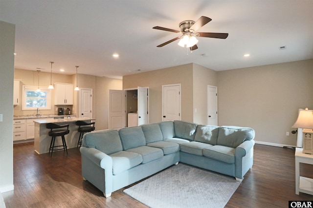 living room with dark wood-style floors, recessed lighting, baseboards, and washer / dryer