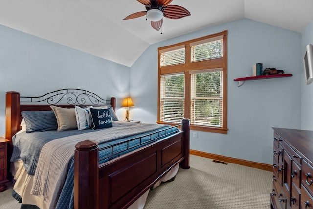 bedroom with lofted ceiling, light colored carpet, visible vents, and baseboards