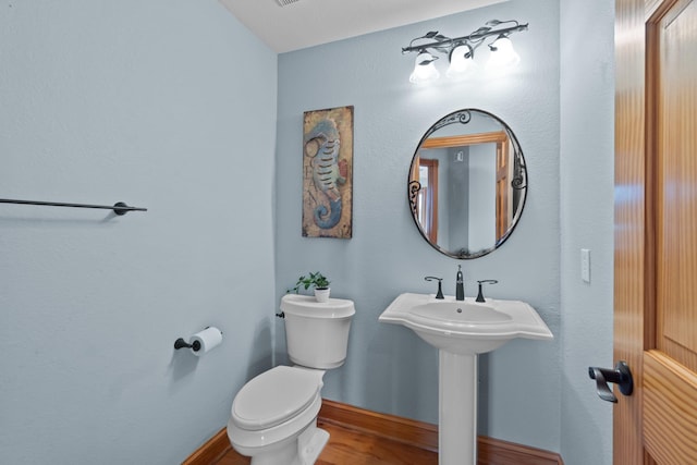 bathroom featuring baseboards, toilet, and wood finished floors