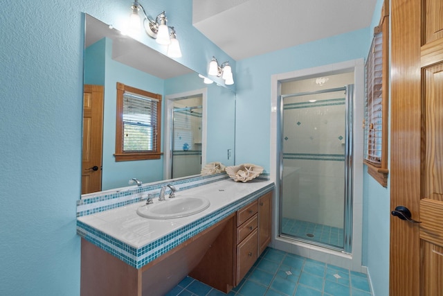 bathroom with a stall shower, tile patterned floors, and vanity