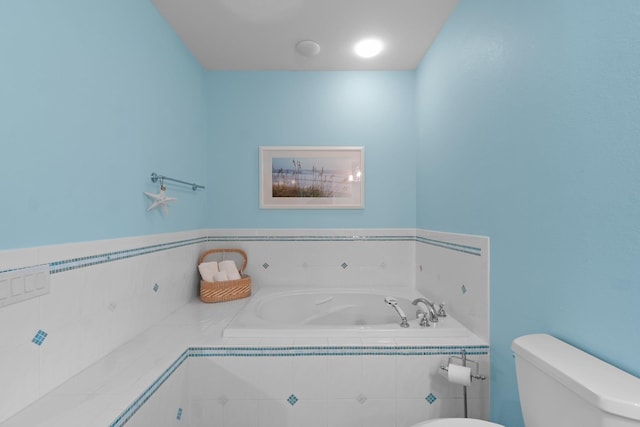 bathroom featuring a garden tub and toilet