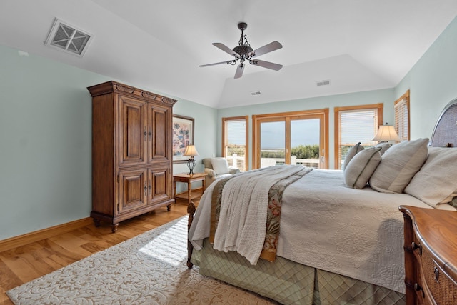 bedroom featuring light wood-type flooring, access to outside, visible vents, and lofted ceiling