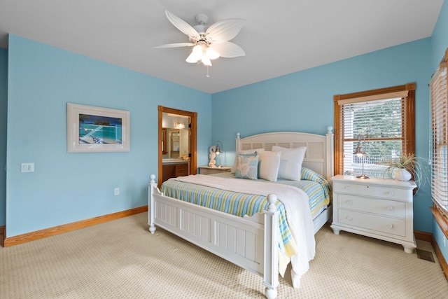 bedroom with light carpet, connected bathroom, baseboards, and a ceiling fan