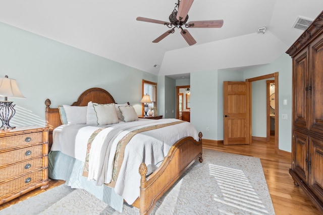 bedroom with ceiling fan, visible vents, baseboards, vaulted ceiling, and light wood-style floors