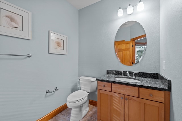 half bath featuring toilet, tile patterned floors, baseboards, and vanity