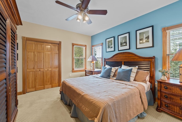 bedroom with ceiling fan, a closet, and light colored carpet