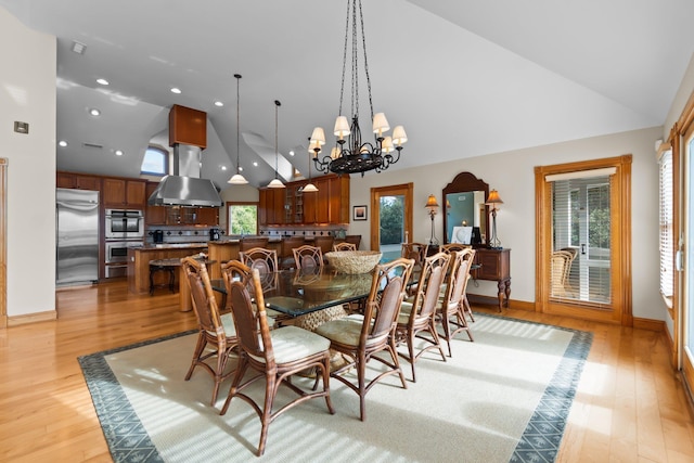 dining room featuring light wood-style floors, high vaulted ceiling, a notable chandelier, and recessed lighting