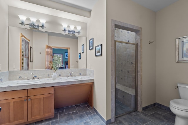 full bath with a stall shower, a sink, toilet, and double vanity