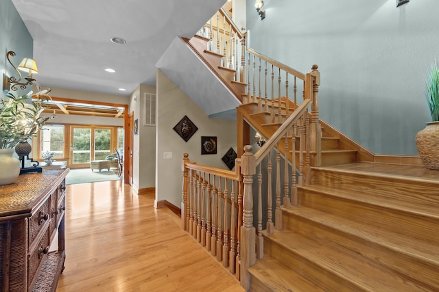 staircase featuring recessed lighting, baseboards, and wood finished floors