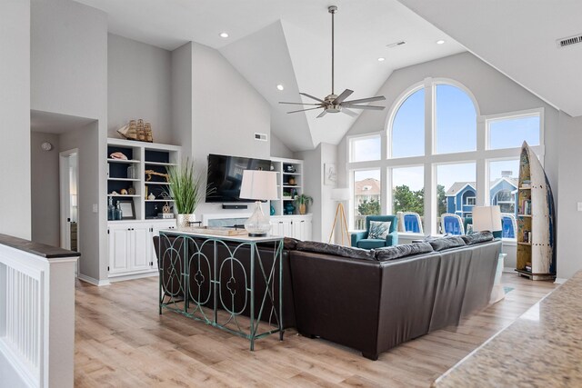 living room featuring visible vents, high vaulted ceiling, light wood-type flooring, and a ceiling fan