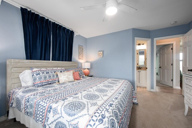 bedroom with ensuite bathroom, baseboards, ceiling fan, and carpet flooring