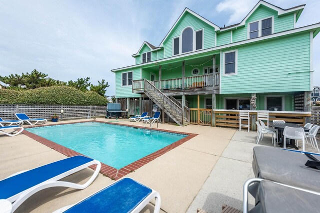 view of swimming pool with stairway, fence, a fenced in pool, and a patio area