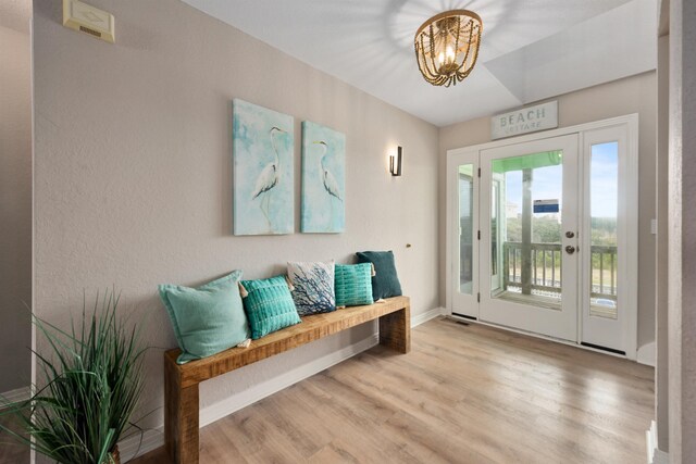 interior space with baseboards, an inviting chandelier, and wood finished floors