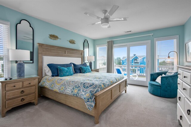 bedroom with ceiling fan, access to exterior, visible vents, and light carpet