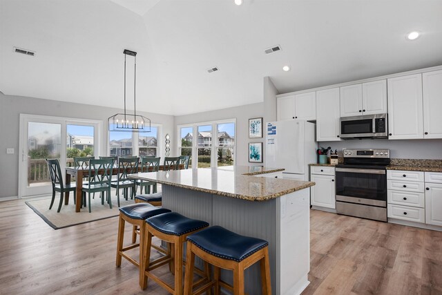 kitchen with visible vents, a kitchen breakfast bar, appliances with stainless steel finishes, and white cabinets