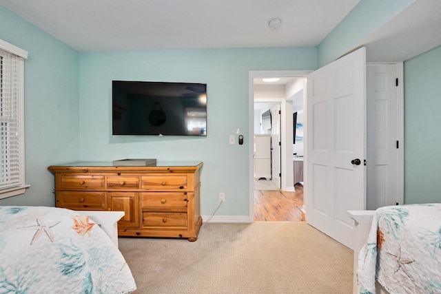 bedroom with baseboards and light carpet