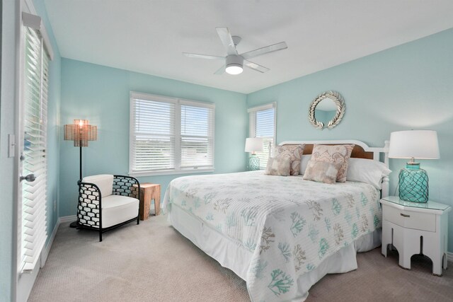 bedroom featuring light colored carpet and a ceiling fan