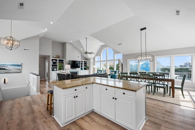 kitchen featuring light wood finished floors, ceiling fan with notable chandelier, open floor plan, and a wealth of natural light