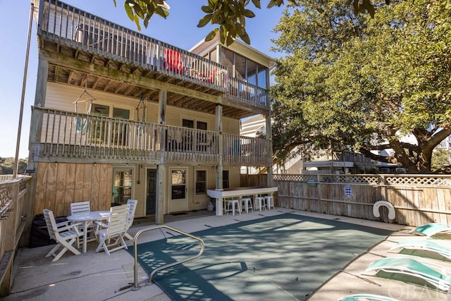 view of patio with outdoor dry bar and fence