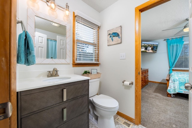 bathroom featuring visible vents, toilet, a ceiling fan, vanity, and baseboards