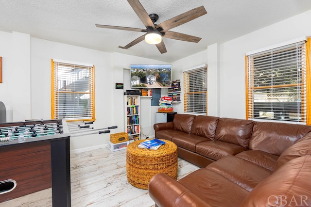 living area featuring a ceiling fan and a textured ceiling