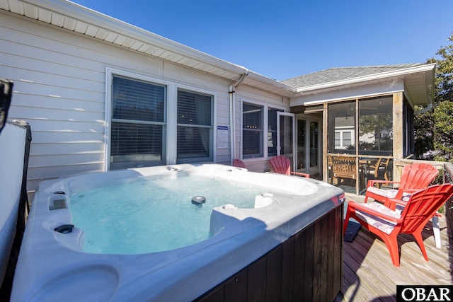 wooden terrace featuring a sunroom and a hot tub